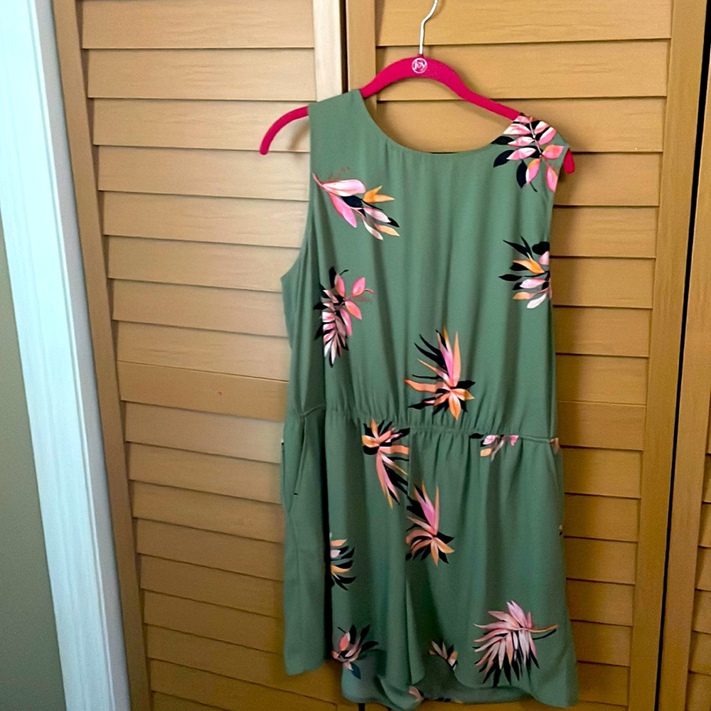 Romper which is light green with pink and black flowers
